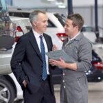 Businessman_talking_to_mechanic_in_auto_repair_shop